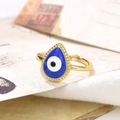 Macro shot of gold adjustable teardrop evil eye ring with blue enamel on beige fabric - Light Blue (ZYN-DMR70G-6)