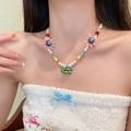 Collier de perles colorées avec tournesols roses et fleur bleue porté par un mannequin - Perles de tournesol colorées (117# Collier)
