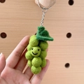 Handmade green wool felt grape keychain with a smiling face and leaf detail - Green Grape