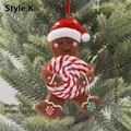 Gingerbread man ornament with red hat and candy cane on green Christmas tree branch - Gingerbread Man with Hat Style K