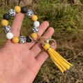 Detail of yellow and leopard print beaded wristlet keychain with gold clasp and tassel - Yellow
