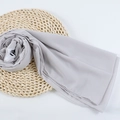 Light gray chiffon hijab scarf with soft texture displayed on a straw mat - 97