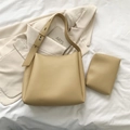 Vue détaillée du sac cabas beige en cuir avec pochette interne sur literie blanche - Kaki