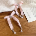 Close-up of pink plush bow earrings with rhinestone snowflake and hanging pearls - Plush Bow Hair Clip
