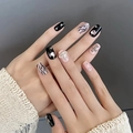 Close-up of luxury press-on nails with black heart rhinestones and punk Saturn charm - By1763 Pink Diamond Crown / Phototherapy Glue Style