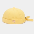Detailed close-up of yellow canvas docker hat featuring 3D lit letter embroidery - Yellow