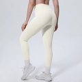 Detail der cremefarbenen Yoga-Leggings mit hohem Bund und Bauchweg-Effekt am Modell - S / Helles Elfenbein