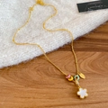 Macro shot of a floral beaded gold necklace draped over a white knitted sweater - Five-Petal Flower with Colorful Beads Style / Gold