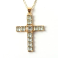 Macro shot of gold cross pendant with blue square gemstones and small white diamonds - Light Blue