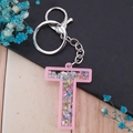 Pink acrylic alphabet T keychain with colorful star sequins and silver metal clasp - Letter T