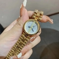 Primer plano de un reloj de cuarzo dorado para mujer con correa metálica y esfera DINIMI - Correa de Acero Dorada Esfera Blanca