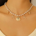 Bohemian pearl necklace with starfish and shell pendants on a model for beach wear - Gold Multi-Pendant Ocean Style Necklace (2015)