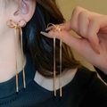 Elegant gold bow tassel earrings with snake chain fringes in a polished finish - Dangle Earrings / Gold