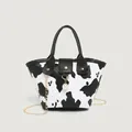 Mini cow print bucket bag with pearl pendant, black leather handle and gold chain strap - Milk Color