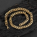 Detail of 11mm golden stainless steel Cuban link chain with lobster clasp on dark wood - 24 Inches (60.96cm) / Gold