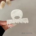 Dettaglio di un fermaglio per capelli in acetato da 6 cm con incisione Barrette La France - Sirena Iridescente