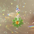 Macro shot of green crystal sunflower suncatcher creating rainbow reflections on window - Single Flower Green