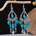 Detail of bohemian tassel earrings with turquoise beads and silver leaf charms on wood - Antique Silver + Turquoise Oval + Leaf (E5775-11)