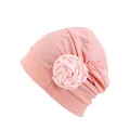 Gros plan d'un turban rose avec texture de tissu plissé et détail de fleur de rose - Champagne