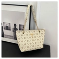 Detail of monogram tote bag with gold chain strap and deer charm on black surface - White