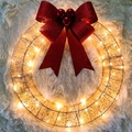 Detalle de corona de Navidad dorada con luces LED y un lazo rojo con purpurina brillante - 50cm / Dorado