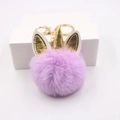 Vue détaillée d'un porte-clés licorne en peluche rose avec corne et oreilles dorées - Violet Taro