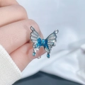 Close-up of irregular silver butterfly ring with blue enamel wings and teardrop charms - Style 4 Butterfly Open Ring