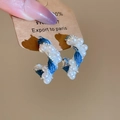 Close-up of C-shaped earrings with denim fabric, silver wire, and faux pearls details - Silver Pin-Silver Base-Blue Denim