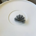 Close-up of glittery spider web hair claw clip for Halloween theme on white plate - Mini Spider Web