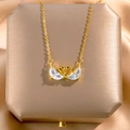 Elegant gold double swan necklace with crystal heart pendant on luxury silk background - Swan Pendant