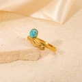 Anillo de serpiente en acero dorado con turquesa sobre fondo de seda de alta calidad - Estilo Serpiente Turquesa (R0732)