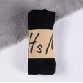 Solid black cotton linen scarf neatly folded with a minimalist kraft paper brand sleeve - Black / One Size