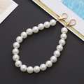 Elegante witte parelmoer telefoonkoord met gouden metalen sluitingen op zwarte basis - 12mm Parel Handketting (K142)