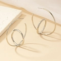 Detail view of silver spiral geometric C-shaped earrings with high-polished mirror finish - Silver