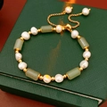 Macro detail of gold-plated bamboo joint beads and baroque pearls on adjustable bracelet - Green