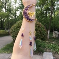 Macro detail of crescent moon suncatcher with purple amethyst and rainbow prisms - Purple Crystal