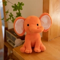 Plush orange baby elephant toy in a sitting position made of soft short fleece - Orange With White Ear Core
