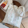 Dettaglio della borsa in cotone floreale su tavolo in legno con decorazione di libri - Floreale a Righe Rosa Carne