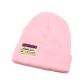 Detail of pink knitted beanie featuring a creative boarding pass theme woven label - Pink