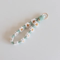 Detailed macro view of handcrafted white daisy crochet keychain with a gold spring ring - White