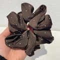 Elastico scrunchie in raso marrone con punti di cristallo lucenti in mano - caffè