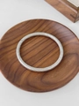 Silver-toned spiral textured titanium steel bangle on a dark wood display base - Silver Plaid