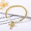 Dettaglio di bracciale di perle dorate con ciondolo aereo micro-pavé di diamanti - Stile 4
