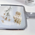 Mini pinza de pelo de acetato con textura de mármol crema sobre superficie de espejo - Blanco Roto