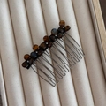 Detail of tortoise shell floral hair comb with rhinestones on a beige tray - Tortoise