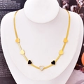 Collana a catena piatta dorata con ciondoli a cuore neri e bianchi su un busto - Solo Collana a Cuore 029