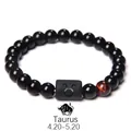 Macro shot of Taurus zodiac charm bracelet with black obsidian and tiger eye beads - Taurus