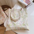 Detailansicht der Leinwandtasche mit pastellfarbenem Blumenmuster und Stoffetikett - Hellgrünes Blatt mit Rosa-Orange Blüten