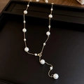French vintage Y-shaped gold pearl necklace with tiered white pearls on a black display - Gold