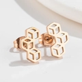 Detalle macro de pendientes geométricos de oro rosa con un diseño moderno de nido de abeja - Oro rosa